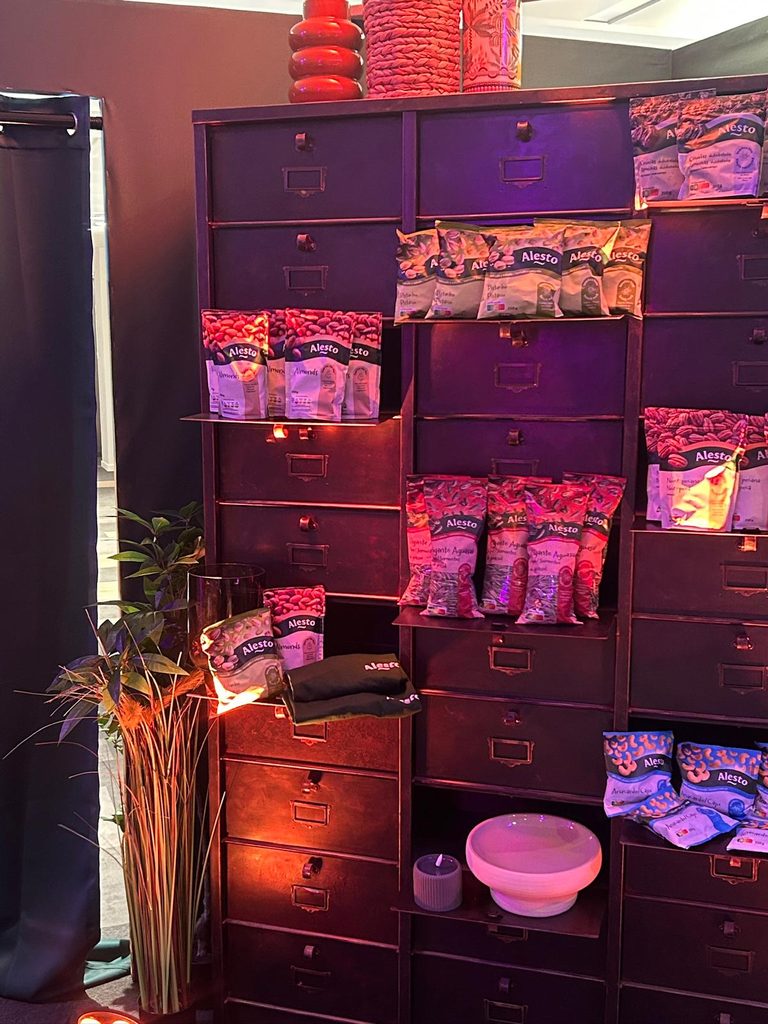 Taquillas llenas de bolsas de frutos secos y snacks de Alesto, con iluminación de color