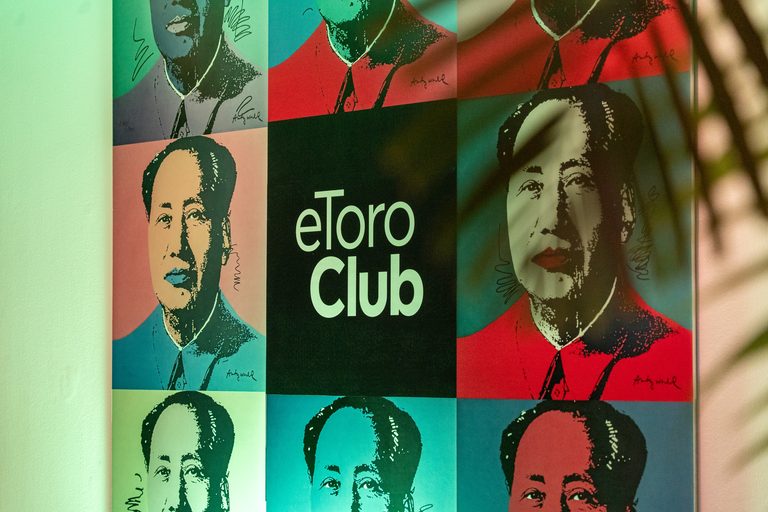 Logotipo de eToro Club sobre la serie de retratos de Mao de Andy Warhol