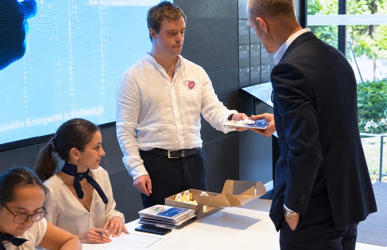 Entrega de documentación a los invitados en la mesa de bienvenida