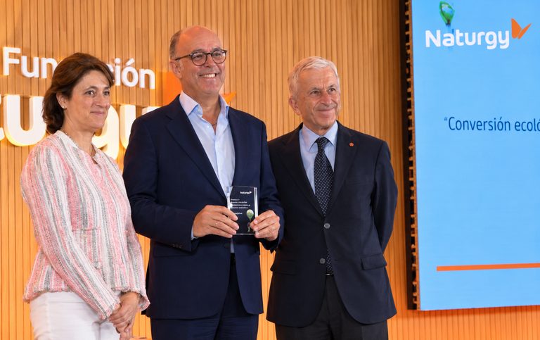 Foto de grupo con el galardón ante la pared de la Fundación Naturgy