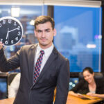 La importancia de la puntualidad en la organización de eventos - businessman stading and holding clock with team wh 2026 01 11 09 08 26 utc