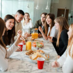 Ideas para desayunos corporativos de networking - cheerful friends gathering at dining table with ju 2025 02 20 09 41 22 utc