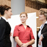 La importancia de los servicios de azafatas en congresos - three businesswomen conversing at professional wor 2026 01 05 23 33 06 utc