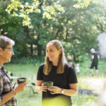Beneficios de realizar retiros empresariales en la naturaleza - women holding cups and standing in meadow 2024 10 17 09 25 06 utc