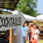 Cómo diseñar la señalización en eventos de gran envergadura 3 Cómo diseñar la señalización en eventos de gran envergadura - wooden directional sign with word cocktails pointi 2026 01 08 05 28 54 utc